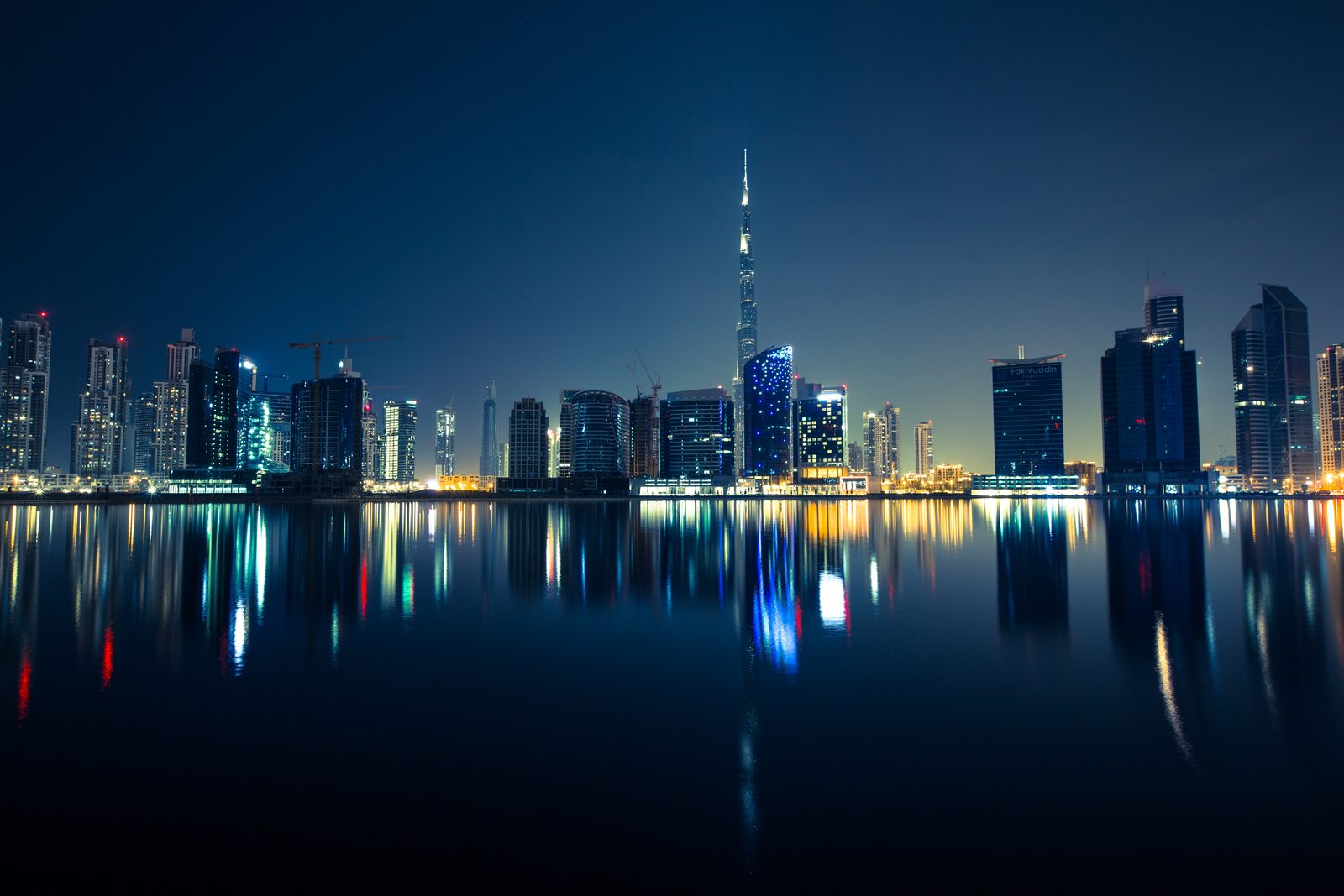 Dubai skyline at night reflected in the water